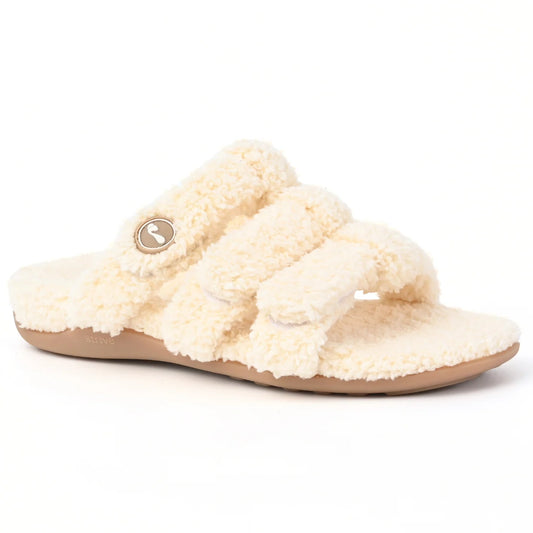 Strive Zella women’s cream orthotic slipper with three adjustable fleece straps and a tan sole, shown from a front side angle.